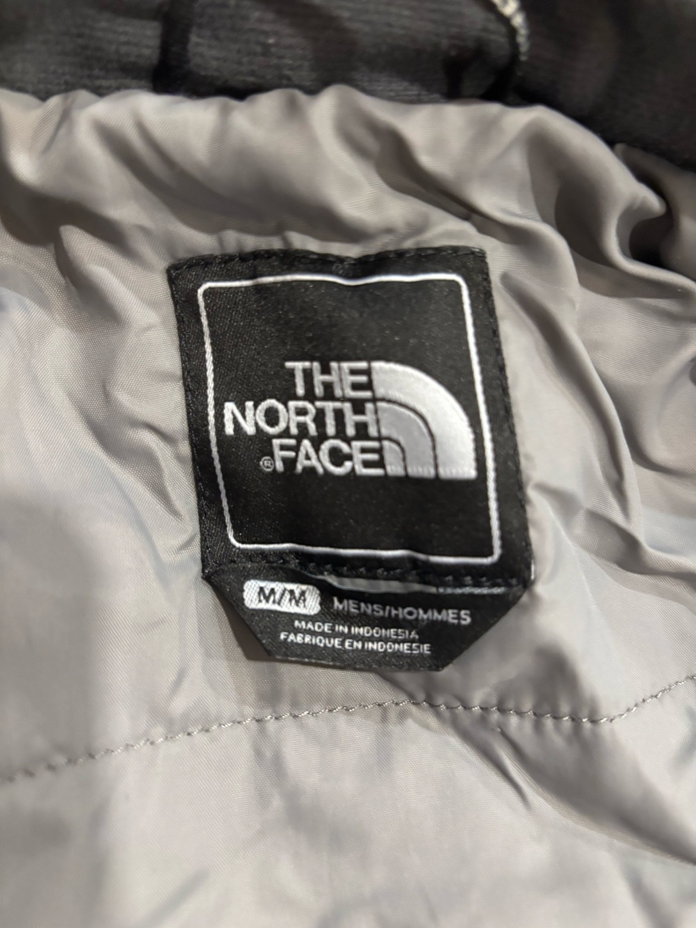 The North Face Black Logo Tag on Light Gray Lining